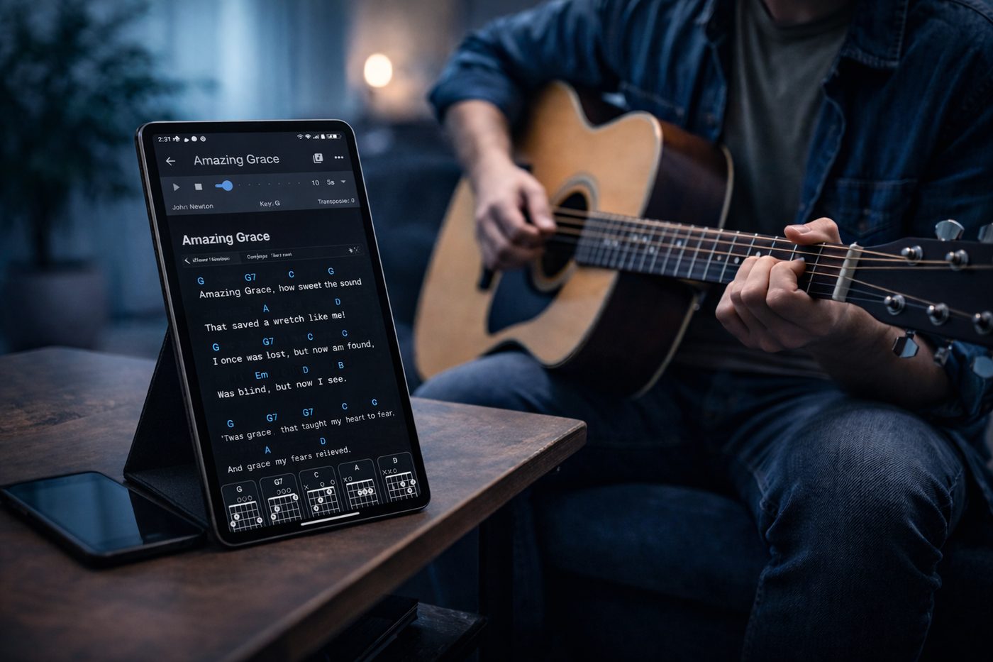 A guitarist playing along to a song with chord diagrams on a tablet